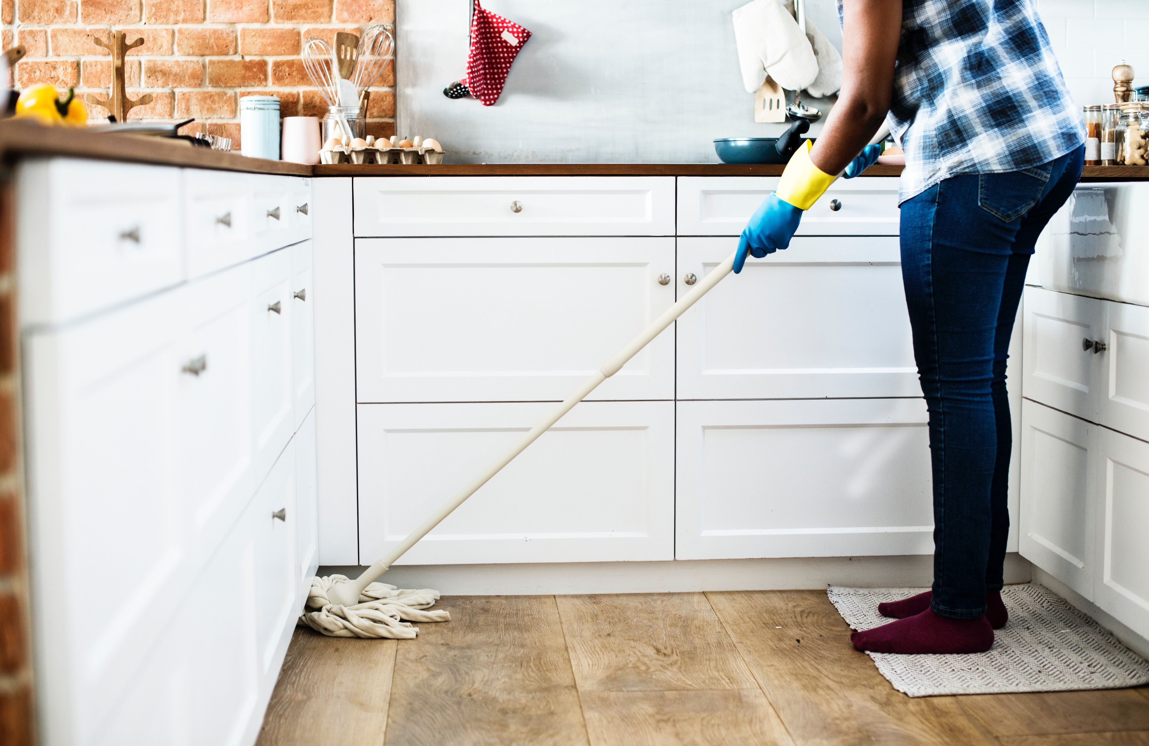 Person cleaning kitchen with mop